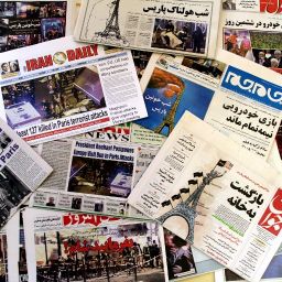 A photo taken on November 15, 2015 in the Iranian capital Tehran shows newspapers bearing the headlines of the deadly Paris attack that left more than 120 people dead, in the worst such violence in France's history. Most Iranian papers dedicated their front pages to terror attacks in Paris that killed at least 129, as conservative papers said France was paying for its policies in Syria. Ultraconservative Vatan-e Emrooz (bottom) printed "Dinner is ready" over the picture of a dead body covered by a white sheet and empty cafe chairs in the background, while a masked jihadist with a gun and a machete was pictured on top of the Eiffel tower in hardliner Javan daily cover (C-R), rasing a mixed flag of the United States and IS while flashing a victory sign. AFP PHOTO / ATTA KENARE